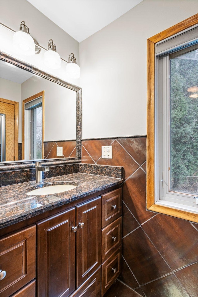 bathroom with tile patterned flooring, vanity, and tile walls