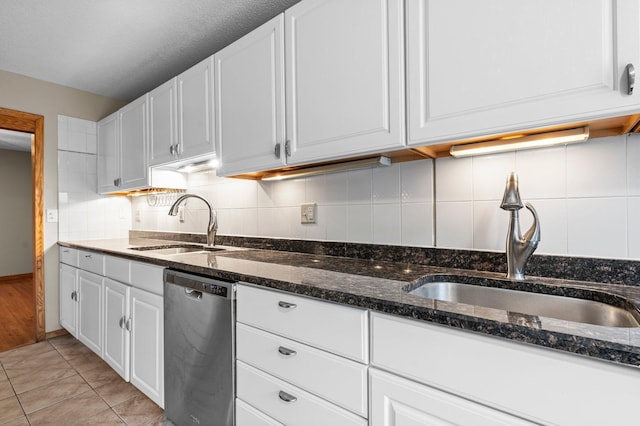 kitchen featuring dishwasher, white cabinets, light tile patterned flooring, and sink