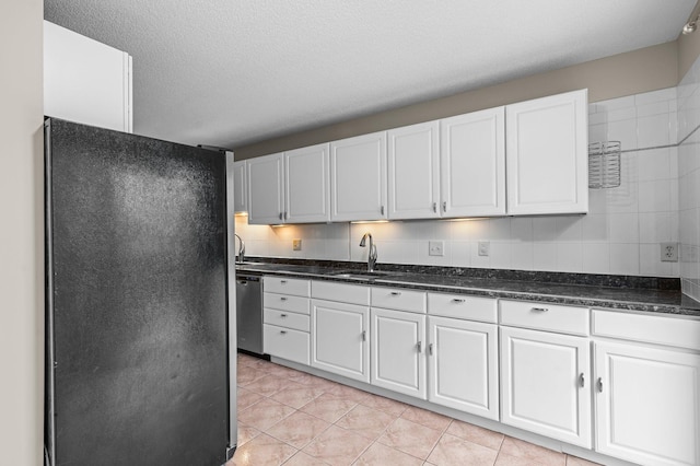 kitchen featuring dishwasher, white cabinets, black refrigerator, sink, and light tile patterned floors