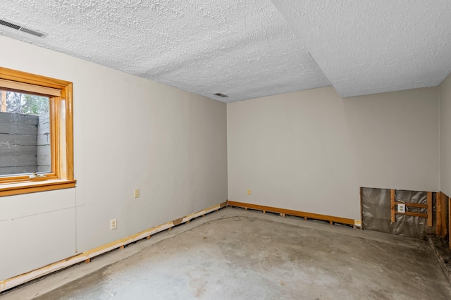 unfurnished room featuring a textured ceiling and concrete floors