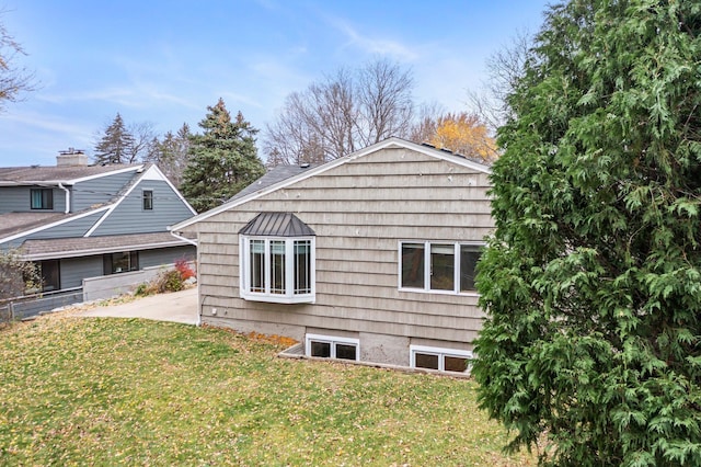 view of side of property featuring a lawn and a patio