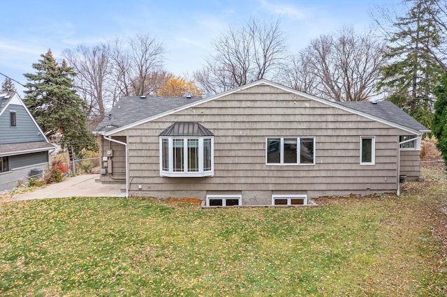 view of side of property featuring a patio area and a lawn