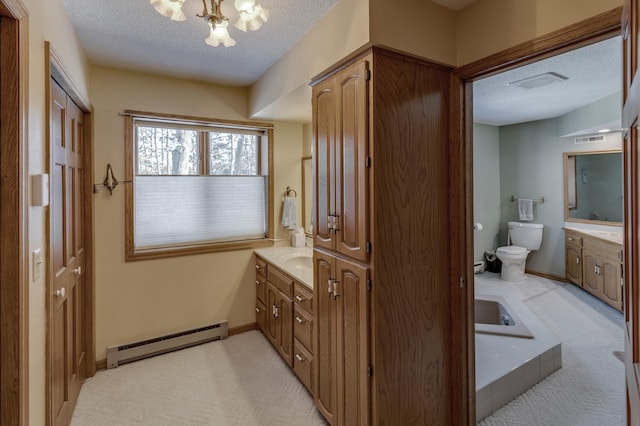 full bath with a textured ceiling, baseboard heating, vanity, and toilet