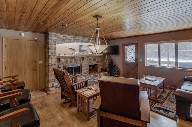 living room featuring wood ceiling, a brick fireplace, and light wood-style floors