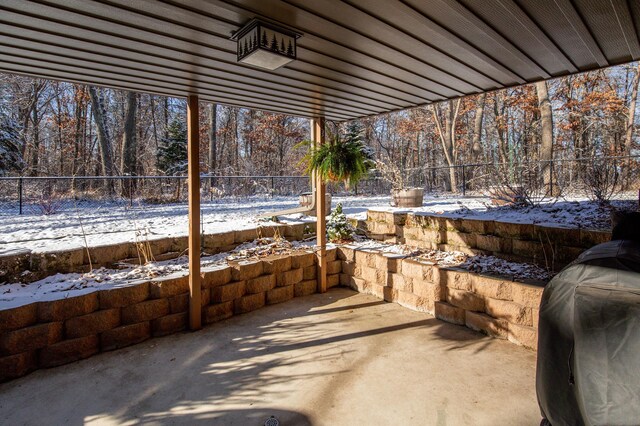 snow covered patio featuring a grill and a fenced backyard