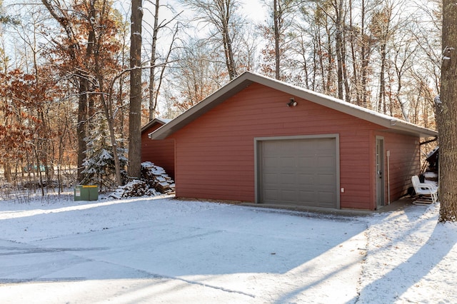 snow covered garage featuring a garage