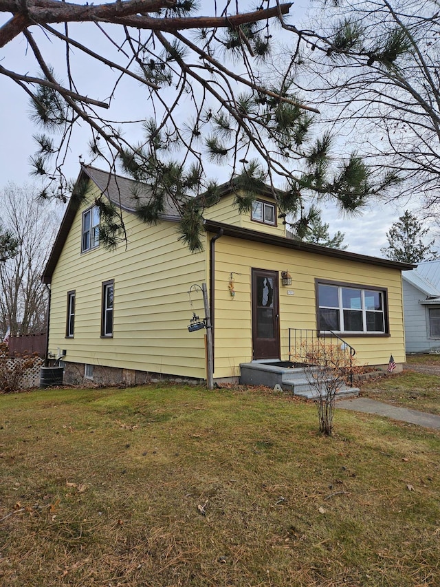 view of front of property featuring central air condition unit and a front lawn