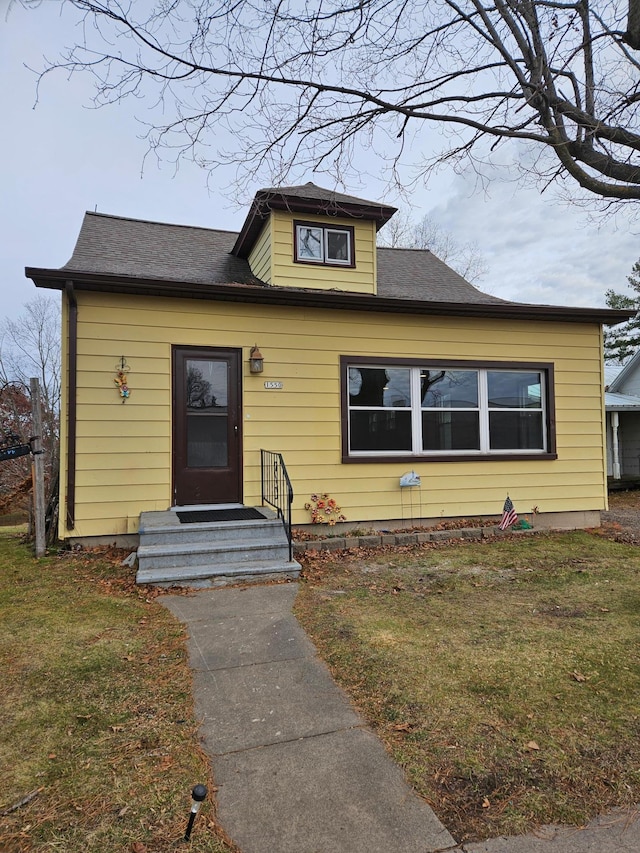 bungalow-style home with a front lawn