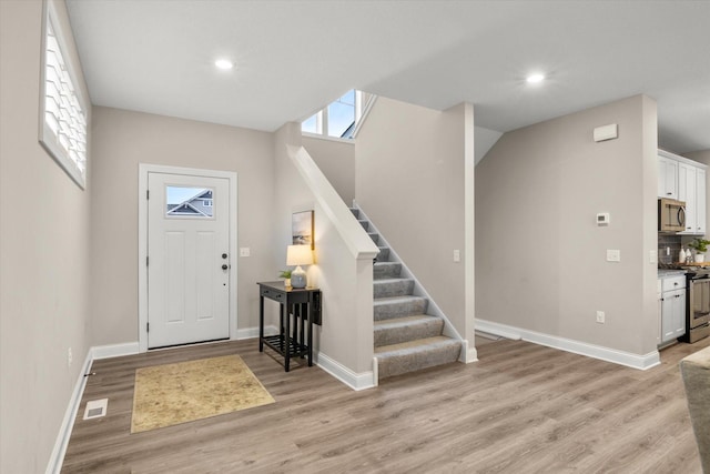 foyer featuring vaulted ceiling and light wood-type flooring