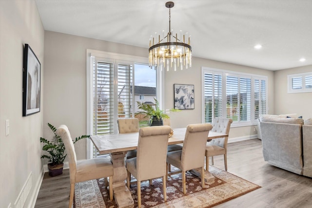 dining room featuring hardwood / wood-style flooring and an inviting chandelier