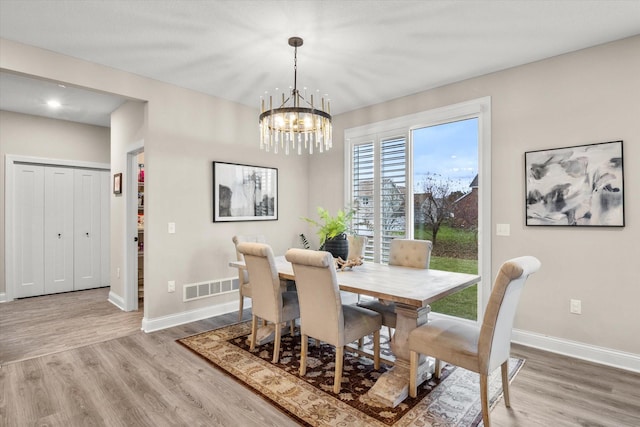 dining area featuring hardwood / wood-style floors and a notable chandelier