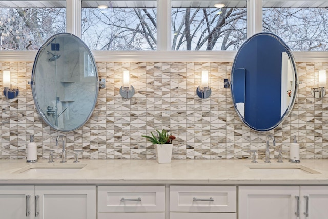 bathroom with decorative backsplash, vanity, and a healthy amount of sunlight