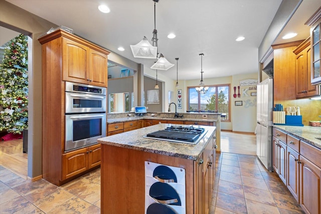 kitchen with pendant lighting, an inviting chandelier, sink, kitchen peninsula, and stainless steel appliances