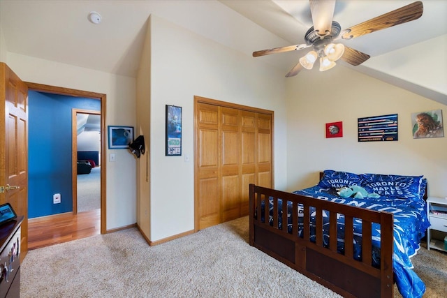 carpeted bedroom with a closet, ceiling fan, and lofted ceiling