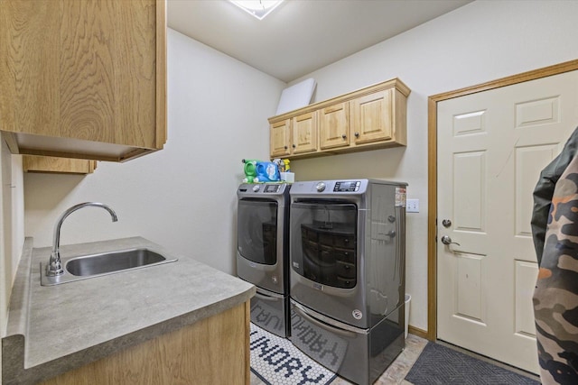 laundry area with washing machine and dryer, sink, and cabinets