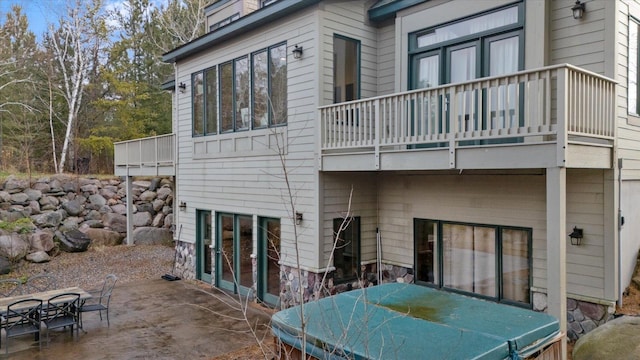 back of property with a balcony and a patio area