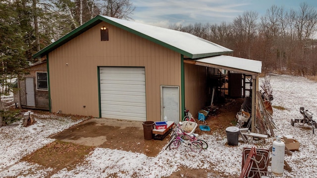 snow covered garage featuring a garage