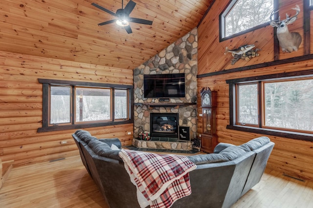 living area with high vaulted ceiling, a stone fireplace, wooden ceiling, wood finished floors, and log walls