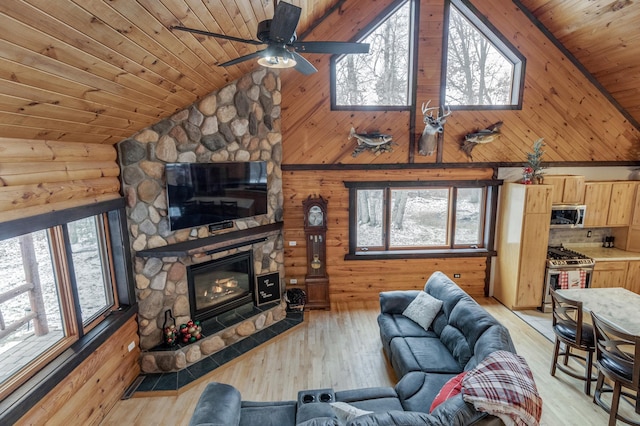 living room with a ceiling fan, wooden ceiling, light wood-style floors, a fireplace, and high vaulted ceiling