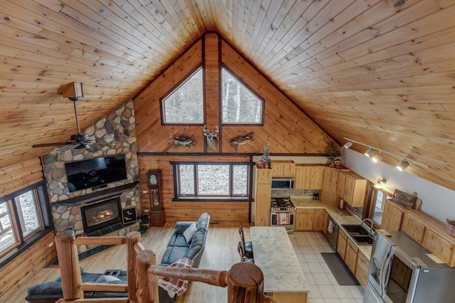 living area with wooden ceiling, wooden walls, a fireplace, and high vaulted ceiling