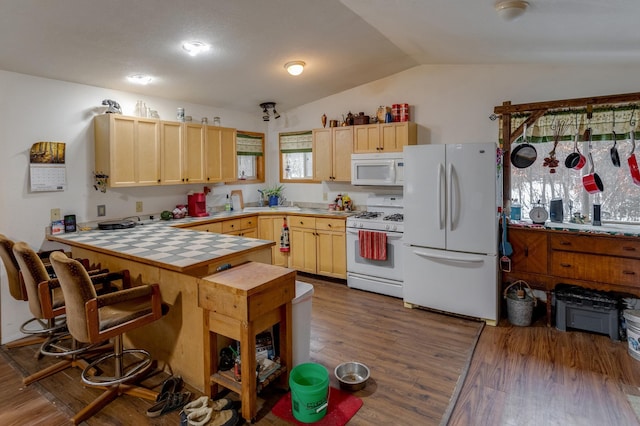 kitchen featuring white appliances, light brown cabinets, tile countertops, and a peninsula