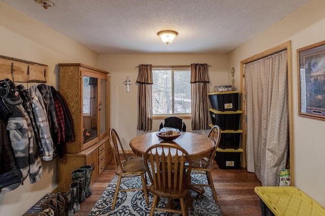 dining room with a textured ceiling and wood finished floors