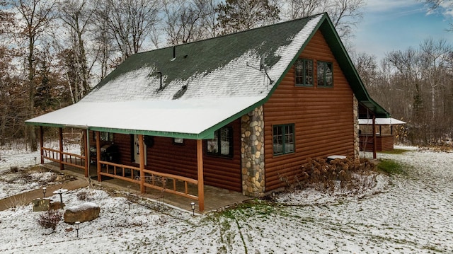 exterior space with a porch and roof with shingles