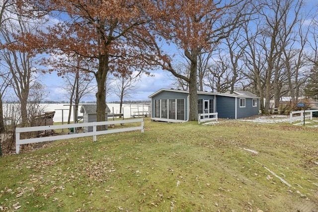 back of house featuring a sunroom and a lawn