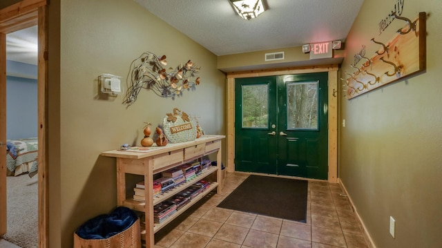 tiled entryway featuring a textured ceiling