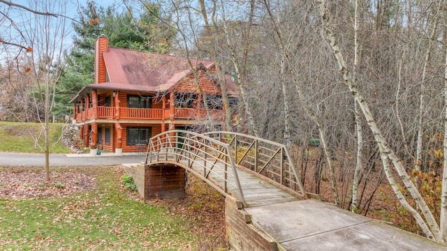 exterior space with log exterior and a chimney