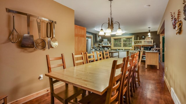 dining area featuring dark wood finished floors, baseboards, visible vents, and a chandelier