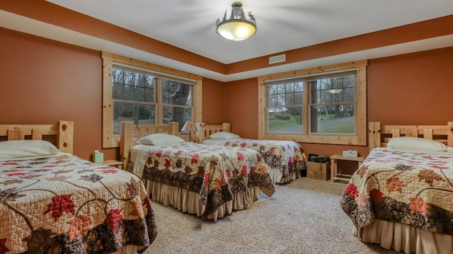 bedroom featuring carpet, visible vents, and multiple windows