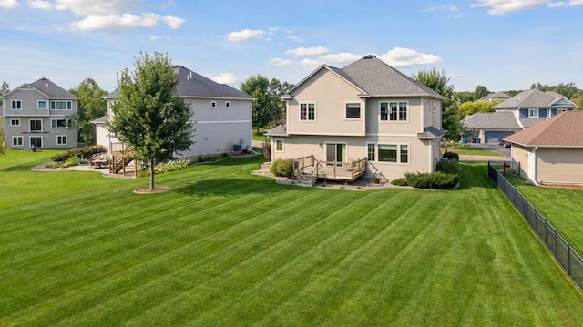 rear view of property with a deck and a yard