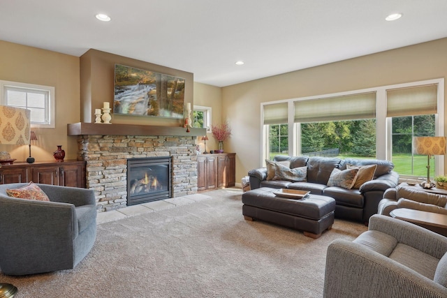 living room with a healthy amount of sunlight, light colored carpet, and a fireplace