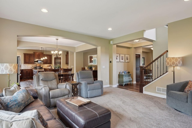 carpeted living room with a chandelier