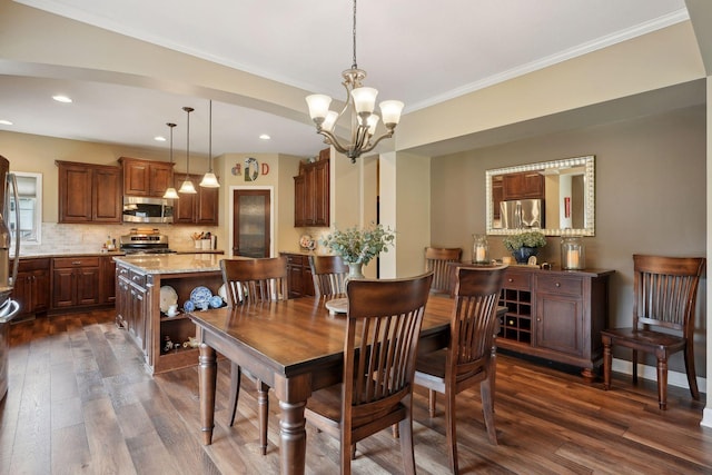 dining area featuring ornamental molding, dark wood-type flooring, and a notable chandelier