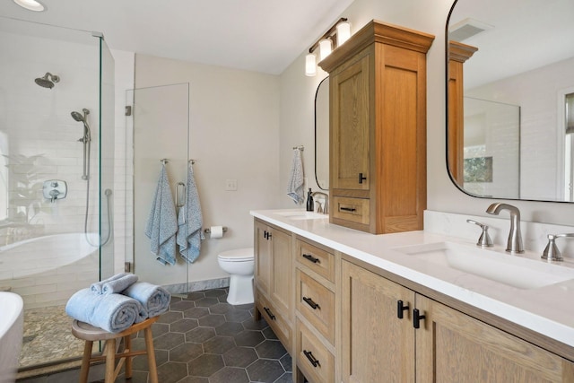 bathroom featuring tile patterned floors, vanity, a shower with shower door, and toilet