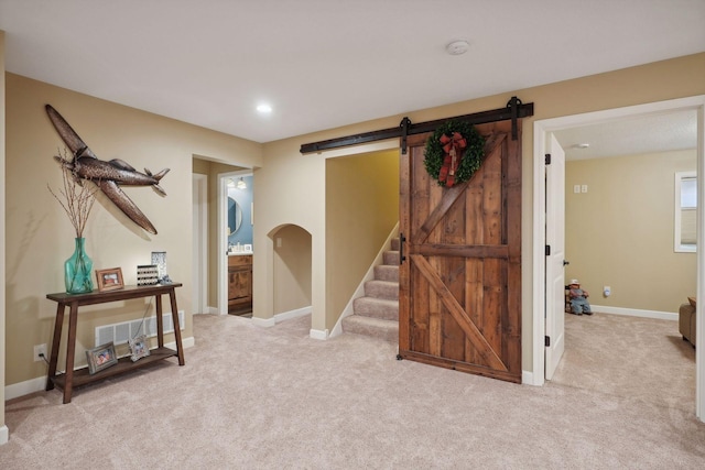 interior space featuring a barn door and light carpet