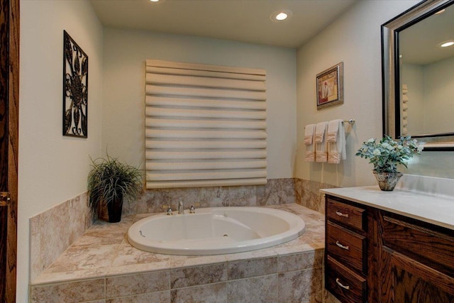 bathroom featuring vanity and a relaxing tiled tub