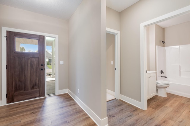 foyer entrance featuring a textured ceiling and light hardwood / wood-style flooring