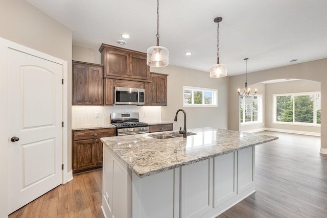 kitchen featuring a wealth of natural light, a center island with sink, sink, and appliances with stainless steel finishes