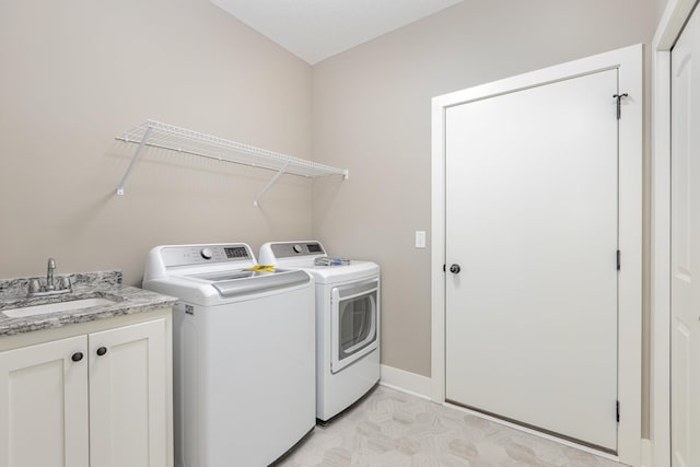 laundry area featuring washer and dryer, cabinets, and sink