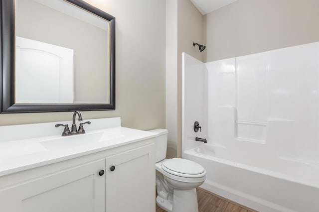 full bathroom featuring hardwood / wood-style floors, vanity, toilet, and shower / washtub combination