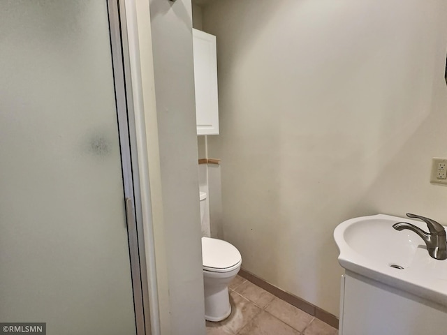 bathroom featuring tile patterned flooring, vanity, toilet, and walk in shower