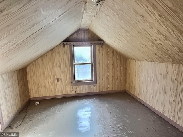 additional living space featuring wooden walls, dark parquet floors, and lofted ceiling