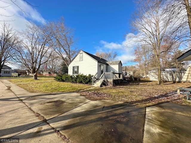 view of home's exterior featuring a lawn and a deck