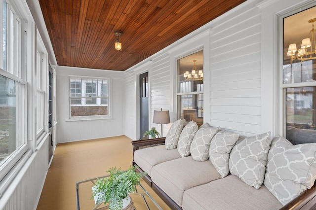 sunroom / solarium featuring wood ceiling and a notable chandelier