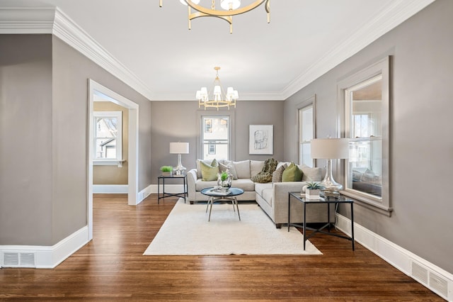 living room featuring crown molding, dark hardwood / wood-style floors, and a notable chandelier