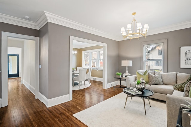 living room with ornamental molding, dark hardwood / wood-style floors, and a notable chandelier