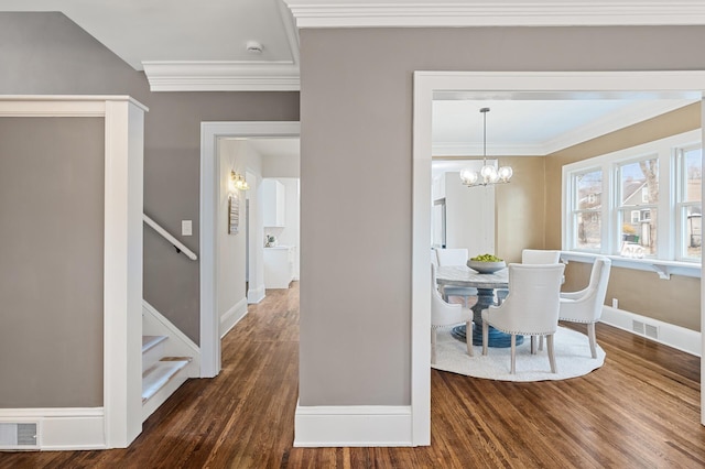 dining room featuring crown molding, dark hardwood / wood-style floors, and an inviting chandelier